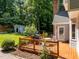 Back yard view with wooden deck, outdoor seating, grill, storage shed and lush green trees at 7605 Pats Branch Dr, Raleigh, NC 27612