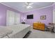 Comfortable bedroom with purple walls, ceiling fan and television at 7605 Pats Branch Dr, Raleigh, NC 27612
