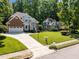 Beautiful home with a long driveway, lush green lawn, and mature trees in a quiet neighborhood setting at 7605 Pats Branch Dr, Raleigh, NC 27612