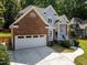 Two-story home with a brick and siding exterior, featuring an attached two-car garage and a well-manicured lawn at 7605 Pats Branch Dr, Raleigh, NC 27612