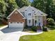 Inviting two-story home featuring a brick and siding facade, well-manicured lawn, and attached two-car garage at 7605 Pats Branch Dr, Raleigh, NC 27612
