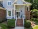 Charming home featuring a brick facade and a welcoming front porch with classic rocking chairs at 7605 Pats Branch Dr, Raleigh, NC 27612