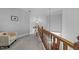 Bright hallway with wooden railing, carpeted floor, and decorative pendant lighting at 7605 Pats Branch Dr, Raleigh, NC 27612