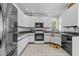 Modern kitchen featuring sleek, white cabinetry, stainless steel appliances, and granite countertops at 7605 Pats Branch Dr, Raleigh, NC 27612