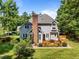 Rear exterior of home featuring a chimney, deck with grill, brick patio and landscaped yard at 7605 Pats Branch Dr, Raleigh, NC 27612