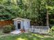 Exterior of the storage shed in the back yard with black door, white trim, and a white picket fence at 7605 Pats Branch Dr, Raleigh, NC 27612