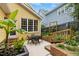 Backyard patio with outdoor seating, mature tropical plants, brick retaining wall, and privacy fence at 800 Highgrove Dr, Chapel Hill, NC 27516
