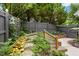 Picturesque backyard garden featuring stone path, wooden fence, and mature foliage at 800 Highgrove Dr, Chapel Hill, NC 27516