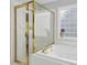 Bathroom features a jacuzzi tub with shower, white tile, and gold trim at 800 Highgrove Dr, Chapel Hill, NC 27516