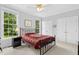Bedroom featuring large windows, a black metal bed frame, and double closets for storage at 800 Highgrove Dr, Chapel Hill, NC 27516