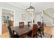 A dining room features hardwood floors, white walls and trim, with a modern light fixture above a wooden table at 800 Highgrove Dr, Chapel Hill, NC 27516