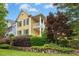 Beautiful yellow house featuring well-maintained landscaping and a charming front porch on a sunny day at 800 Highgrove Dr, Chapel Hill, NC 27516