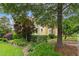 Manicured front yard showcasing lush landscaping around a yellow home, creating a picturesque and inviting curb appeal at 800 Highgrove Dr, Chapel Hill, NC 27516