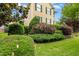 View of a well-manicured front yard with colorful landscaping and a charming yellow house in the background at 800 Highgrove Dr, Chapel Hill, NC 27516