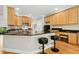 A kitchen offers light wood cabinets, granite counters, and two black stools at the breakfast bar at 800 Highgrove Dr, Chapel Hill, NC 27516