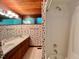 Bathroom showcasing a shower/tub, sink, and patterned wallpaper at 808 Indian Springs Rd, Chapel Hill, NC 27514