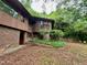 View of the house showing the brick facade, wood exterior, green space and an ADT security sign at 808 Indian Springs Rd, Chapel Hill, NC 27514