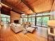 Cozy living room with wood-paneled ceilings, hardwood floors, a brick fireplace, and ample natural light at 808 Indian Springs Rd, Chapel Hill, NC 27514