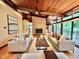 Open-concept living room boasts a brick fireplace, hardwood floors, and expansive windows with wooded views at 808 Indian Springs Rd, Chapel Hill, NC 27514