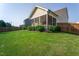 Well-manicured backyard featuring a green lawn, mature landscaping, and a screened-in porch at 857 Mill Station Ln, Wendell, NC 27591