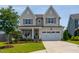 Charming two-story home with a well-manicured lawn, inviting porch, and a two-car garage at 857 Mill Station Ln, Wendell, NC 27591