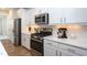 Contemporary kitchen with white cabinets, stainless steel appliances, and quartz countertops at 857 Mill Station Ln, Wendell, NC 27591