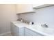Bright laundry room features white cabinetry, sink, and washer and dryer at 857 Mill Station Ln, Wendell, NC 27591