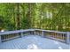 Relaxing back deck surrounded by trees and nature, a wooden patio, and blue-painted railings at 904 Oldwyck Dr, Fuquay Varina, NC 27526