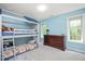 Bedroom with a bunk bed with an attached playhouse, a dresser, and light-blue painted walls at 904 Oldwyck Dr, Fuquay Varina, NC 27526