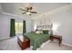 Bedroom with a tray ceiling, carpeted floors, large bed, side tables, and a window with views of the outdoors at 904 Oldwyck Dr, Fuquay Varina, NC 27526