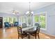 Elegant dining room with plenty of natural light from windows and doors, wooden floors, and a stylish chandelier at 904 Oldwyck Dr, Fuquay Varina, NC 27526