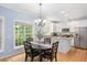 Open-concept kitchen and dining area with white cabinetry, stainless steel appliances, granite countertops and a view of the backyard at 904 Oldwyck Dr, Fuquay Varina, NC 27526
