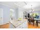 Bright open-concept kitchen with granite island countertop, white cabinets, and eat-in kitchen area at 904 Oldwyck Dr, Fuquay Varina, NC 27526