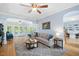 Open-concept living space with hardwood floors, a large sofa, windows, and a view of the backyard and adjacent office space at 904 Oldwyck Dr, Fuquay Varina, NC 27526