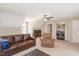 Cozy living room with a sofa, swivel chair, ceiling fan, carpeted floor, and natural light at 904 Oldwyck Dr, Fuquay Varina, NC 27526
