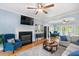 Bright living room featuring hardwood floors, a fireplace, windows, and stylish furnishings at 904 Oldwyck Dr, Fuquay Varina, NC 27526