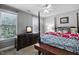 Well-lit bedroom with a 4 post bed, dark dresser, and a bench at the foot of the bed at 908 Town Side Dr, Apex, NC 27502