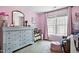 Bright bedroom with a blue dresser, pink accent wall, and large window at 908 Town Side Dr, Apex, NC 27502