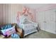 Cozy Bedroom with a crib, cushioned armchair, and charming pink decor, perfect for a baby at 908 Town Side Dr, Apex, NC 27502