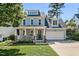 Charming two-story home with a welcoming front porch and well-maintained lawn and an attached two-car garage at 908 Town Side Dr, Apex, NC 27502