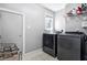 Clean laundry room with a modern washer and dryer set, storage shelf, and tiled floor at 908 Town Side Dr, Apex, NC 27502