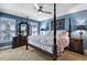 Bedroom with four-poster bed, dark wood furniture, and tranquil blue walls at 908 Town Side Dr, Apex, NC 27502