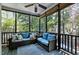 Relaxing screened porch featuring comfortable wicker seating, ceiling fan, and view of trees at 908 Town Side Dr, Apex, NC 27502