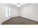 Bright bedroom features a large window, ceiling fan, and neutral carpet at 911 Washington St # 304, Raleigh, NC 27605