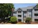 Beautiful three-story condo building featuring gray siding, white trim, and brick accent wall at 911 Washington St # 304, Raleigh, NC 27605