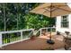 Expansive back deck with a shady umbrella and views of the lush, green treeline at 9136 Palm Bay Cir, Raleigh, NC 27617