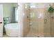 Bright bathroom with large window, soaking tub, and glass shower with chrome plumbing fixtures at 9136 Palm Bay Cir, Raleigh, NC 27617