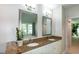 Bright bathroom featuring double vanity, granite countertops, and decorative framed mirrors at 9136 Palm Bay Cir, Raleigh, NC 27617