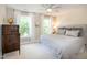 Bright bedroom featuring natural light from windows, a ceiling fan, and neutral decor for a serene atmosphere at 9136 Palm Bay Cir, Raleigh, NC 27617