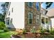 Exterior angle of a home showing stone detailing and manicured landscaping, enhancing its aesthetic appeal at 9136 Palm Bay Cir, Raleigh, NC 27617